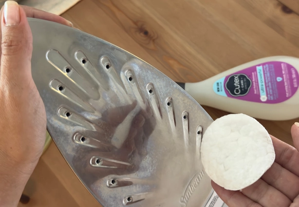 Cleaning an iron soleplate using nail polish remover and a cotton pad