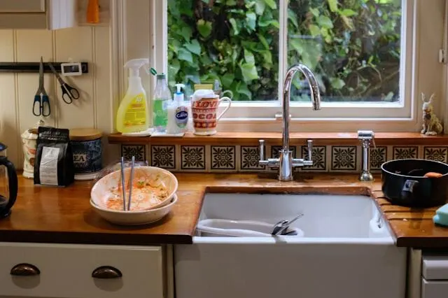 dirty bowls on top of the kitchen counter and dishes in the sink 