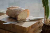 wooden cutting board with half loaf on it